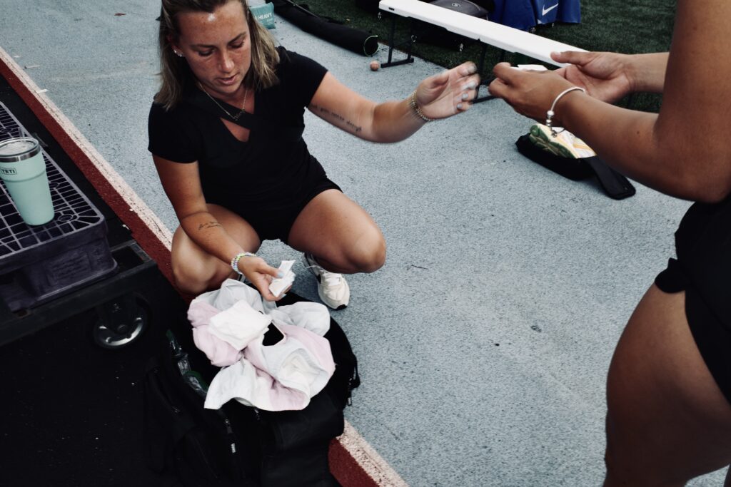 Athletic trainer Cally Beltz helps a player with medical supplies.